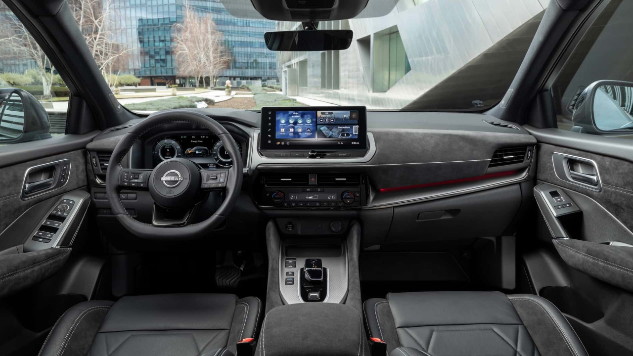 Habitacle du Nissan Qashqai 2025 vu depuis les sièges arrière avec tableau de bord et écrans numériques.