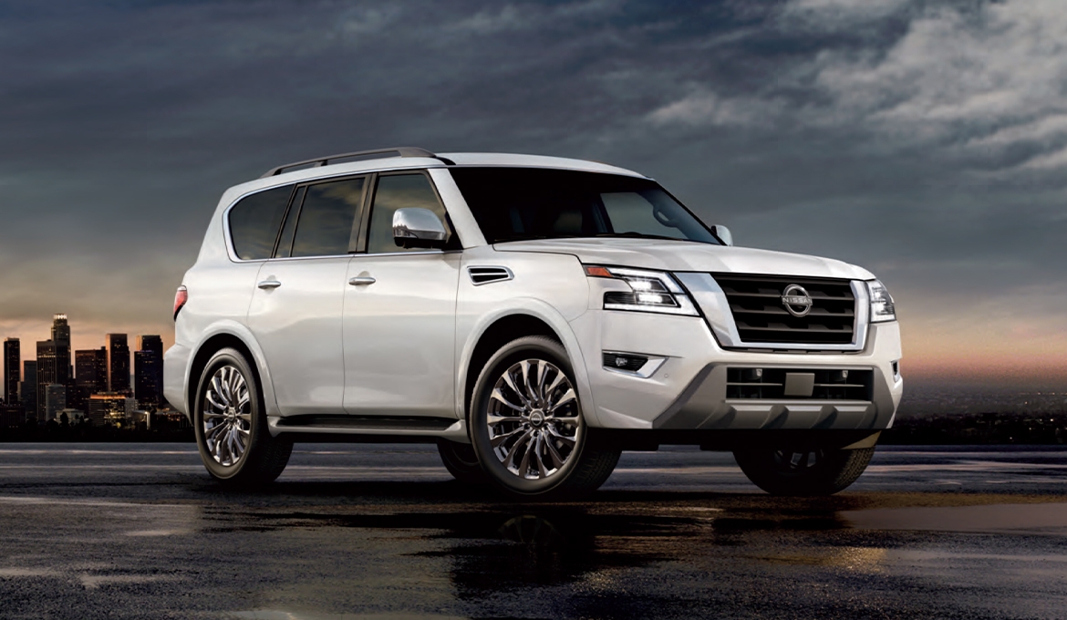 Vue 3/4 avant et latérale du Nissan Armada 2025 avec vue sur ville en soirée